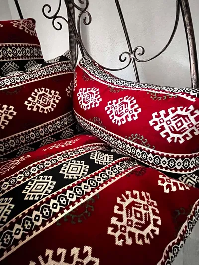 SELMIN KREATIVNI KUTAK Bakreno patinirana ljuljačka pocinčana sa etno motivom jastuka u crvenoj boji.